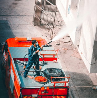 man in blue jacket and blue denim jeans sitting on red truck